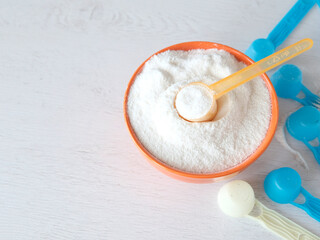 Blue plastic spoon with powder, infant formula, flour. Close-up. Dairy cuisine concept. Healthy food for early infants.