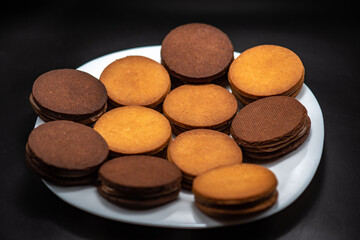 Round roast with chocolate in confectionery on a black background