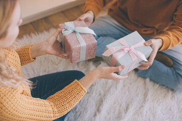 Closeup of a couple exchanging christmas presents, gifts