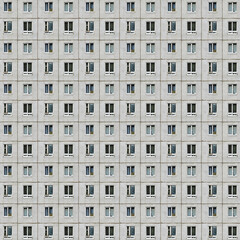 Seamless pattern from picture of a prefabricated concrete building facade with gray colors, a symbol of drab mass housing in anonymous condos and the urban city life