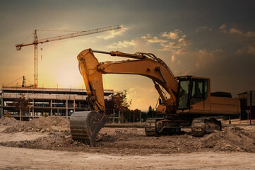 A large excavator at a construction site with cranes and scaffolding in the background © Enrique del Barrio