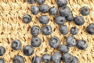 Ripe blueberries on a straw mat.