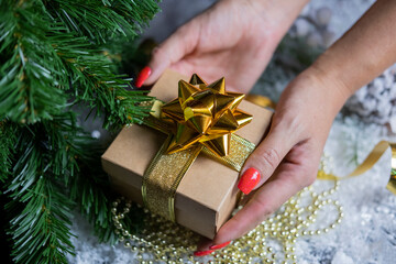 
beautiful festive surprise box gift golden with a bow girl holding in her hands near the christmas...