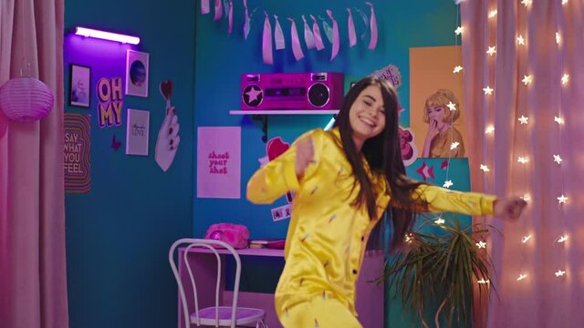 Happy and pretty lady with a large smile in the mor wake up with a good mood and dancing in her bedroom and feeling excited