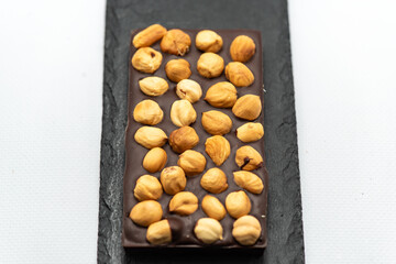 Chocolate bar with the addition of fruit nuts on background. Dessert food concept.