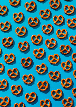 Pattern of salty pretzels over a light blue background