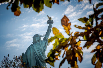 statua della libertà vista tra le foglie