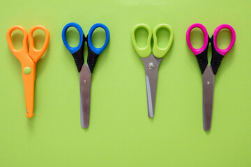 Scissors set on green background, School preschool supplies, top view
