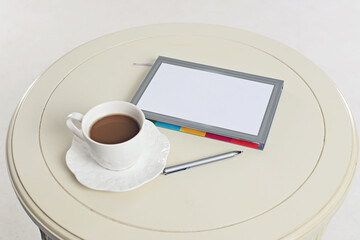 white round table with a Cup and a notebook