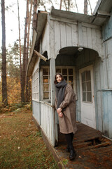 young woman in the autumn forest near the old house