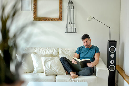 Hombre leyendo un libro en casa. Concepto confinamiento.