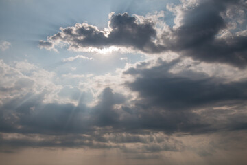 Fototapeta na wymiar Dramatic clouds and sun behind on sky background