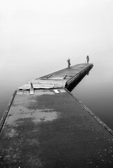 Lonely woman on the edge of a pier at the small fishing port of Agios Achilleios islet, Mikri Prespa lake, Florina, Macedonia, Greece.
