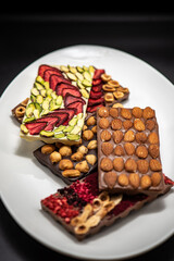 Chocolate bar with the addition of fruit nuts on background. Dessert food concept.