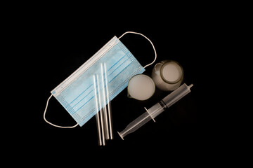 Medical mask, test tubes for experiments with smoke on a black background. For laboratory experiments.