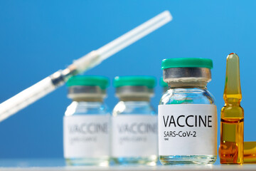 Sars-cov-2 vaccine vial and syringe on white table