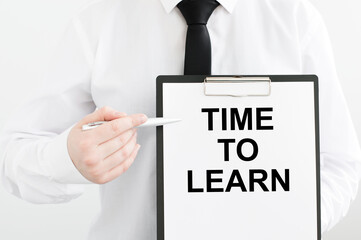 card with text TIME TO LEARN in the hands of a man on a light background