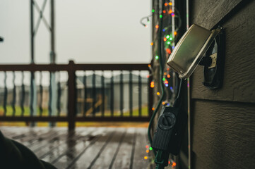 Outdoor timer and GCFI outlet with cover. Blurred christmas lights in background.