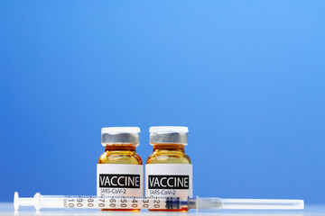 Sars-cov-2 vaccine vial and syringe on white table