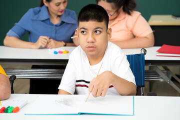 Naklejka premium disability boy sitting on wheelchair in classroom special with teacher and AUtism kids education