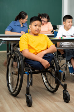 disability boy sitting on wheelchair in classroom special with teacher and AUtism kids education