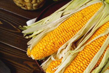 Corn cobs on dark brown wooden table