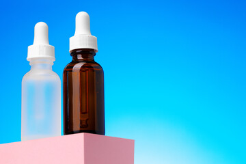 Beauty oil bottle with pipette against blue background