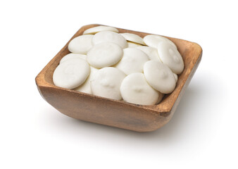 Wooden bowl of white chocolate buttons