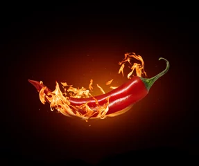 Keuken spatwand met foto Rode chili peper close-up in een brandende vlam op een zwarte achtergrond © Krafla