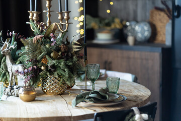 Festive table setting for the new year and christmas. Beautiful decorations, dishes, candles. Quiet family dinner during self-isolation due to covid.