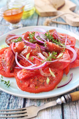 Tomato salad with red onion and spicy sauce of different varieties of tomatoes