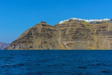 Fototapeta na wymiar A panorama view from a boat towards Skaros Rock, Santorini in summertime