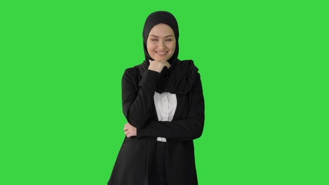 Smiling Arab businesswoman wearing hijab posing for the camera on a Green Screen, Chroma Key.