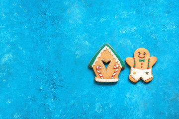 Christmas gingerbread man and house on turquoise blue grunge background. Top view, flat lay, copy space.
