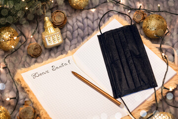 Mask and a letter to Santa on a knitted background among Christmas decorations