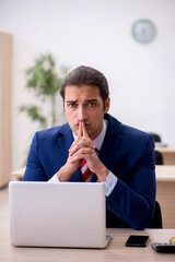 Young male employee sitting in the office