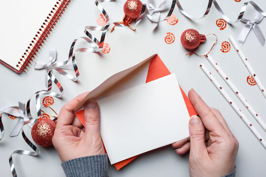 Happy New Year 2021. Woman's hand writing in notebook decorated with Christmas decorations on the grey background. Top view, flat lay - Powered by Adobe