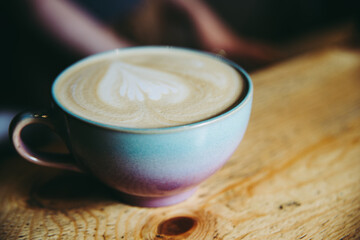 pouring milk into a cup of coffee. making latte, cafe. Barista is making coffee. Coffee in beautiful ceramic blue purple magenta color cup. Coffee shop.coffee in the morning.