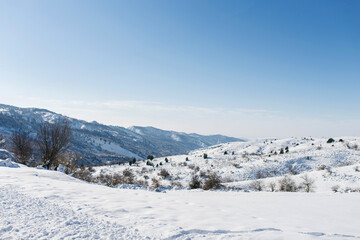 Fototapeta na wymiar Snow on the Mountain Peaks on a clear Sunny winter day, Chimgan, Uzbekistan