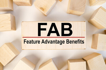 FAB - Feature Advantage Benefits, text on wood block on light background