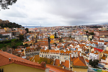 Fototapeta na wymiar view over the capital of Portugal Lisbon Lisboa colorful buildings with mostly orange roofs Ponte 25 de Abril