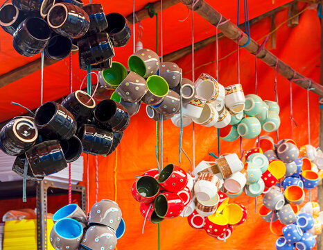 Traditional colorful ceramic cups are displayed for sale.