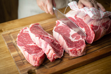 butcher slicing chunk of beef rib eye