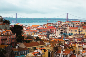 Fototapeta na wymiar view over the capital of Portugal Lisbon Lisboa colorful buildings with mostly orange roofs Ponte 25 de Abril 
