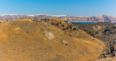 A view across the volcanic island of Nea Kameni, Santorini towards the caldera in the background in summertime