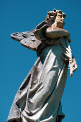 sculpture of angel with blue sky in the background