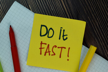 Do it Fast! write on sticky notes isolated on Wooden Table.