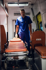 Medical worker on duty, standing in an ambulance car.