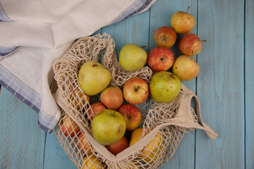 Top view of organic apples in eco friendly meshed shopping bag with white linen napkin. No waste, zero plastic, eco friendly, reusable concept
