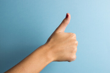 hand with thumb up on blue background. Concept of positivity and good